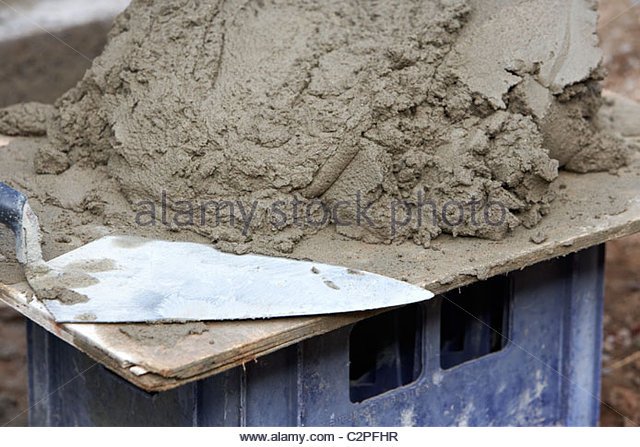 bricklaying-trowel-and-mortar-piled-up-on-a-wooden-board-ready-for-c2pfhr.jpg