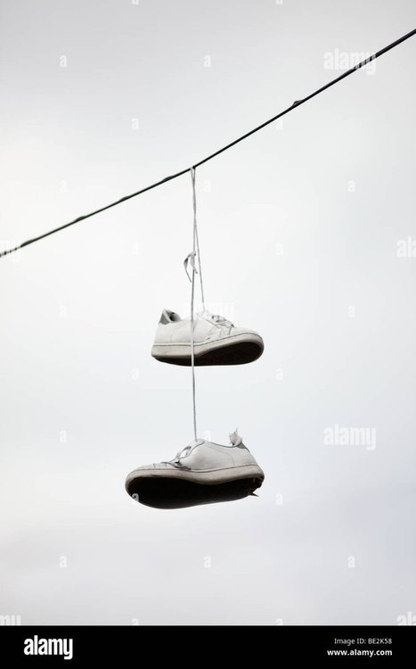 a-pair-of-trainers-hanging-from-a-telephone-wire-birmingham-england-BE2K58.jpg